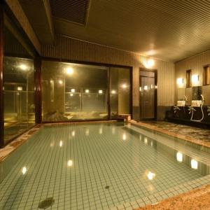 a large swimming pool with lights in a room at Nakamatsuya Ryokan in Ueda