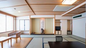 un soggiorno con tavolo e sedie di Nakamatsuya Ryokan a Ueda