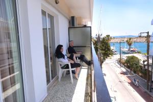 a man and woman sitting on a balcony looking out at the ocean at Veroniki Hotel in Kos