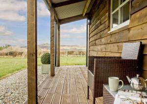 a wooden porch with a view of a field at Caban in Cross Foxes