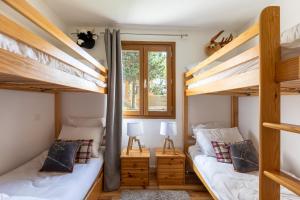 een slaapkamer met 2 stapelbedden en een raam bij Le Reflet du Lac - Station ski accessible à pied in Les Angles