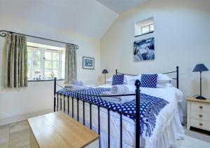 a bedroom with a bed with blue and white sheets at The Dairy in Llandegfan