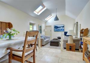 a living room with a table and a living room with skylights at The Dairy in Llandegfan