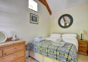 a bedroom with a bed and a vanity and a mirror at The Dairy in Llandegfan