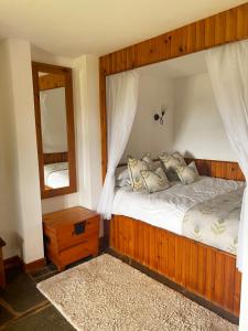 um quarto com uma cama de madeira e um espelho em Tigh Phadraig at Marys Thatched Cottages em Elgol