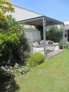 een paviljoen met een bank eronder in een tuin bij Casa da Ribeira in Aldeia do Meco