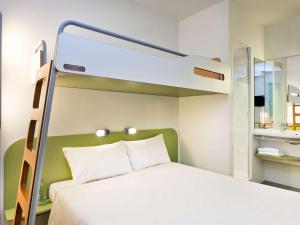 a bedroom with a bunk bed with a white bed at ibis budget Giessen Linden in Gießen