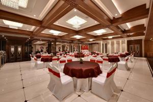 una grande sala banchetti con tavoli e sedie bianche di The Fern Shelter Resort Palghar a Manor