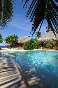 una piscina con playa y un complejo en Green Lodge Moorea, en Teavaro