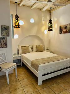 a bedroom with a bed and pendant lights at Navy Blue Suites in Ornos