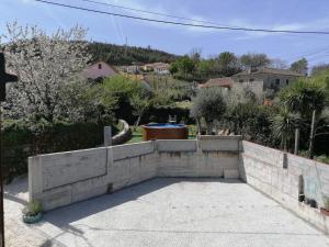a stone retaining wall in front of a yard at Casa do Meio in Alcofra