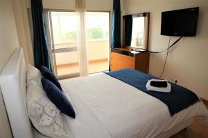1 dormitorio con 1 cama grande y TV en la pared en Supreme Areeiro Luxury New, en Lisboa
