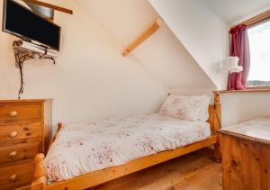 um quarto com uma cama e uma televisão na parede em The Granary em Cheriton