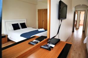 a bedroom with a bed with a mirror and a television at Supreme Areeiro Luxury New in Lisbon