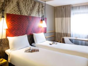 una camera d'albergo con due letti e una finestra di ibis Manchester Centre Princess Street a Manchester