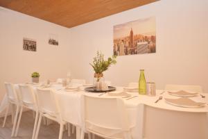 a white room with a long table and white chairs at CO07-HI Apartment in Coburg in Coburg