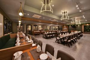 una sala da pranzo con tavoli, sedie e lampadari a braccio di The Fern Shelter Resort Palghar a Manor