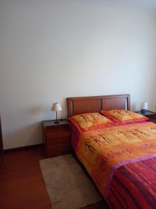 Casa do Olival في فيلا فلور: غرفة نوم بسرير وطاولة مع مصباح