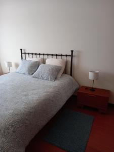 Casa do Olival في فيلا فلور: غرفة نوم بسرير مع وسادتين وطاولة
