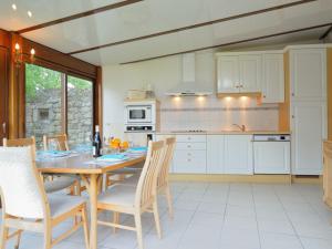 uma cozinha com uma mesa de madeira e cadeiras num quarto em Holiday Home Moulin Bastard by Interhome em Le Croisic