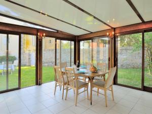 a dining room with a table and chairs and windows at Holiday Home Moulin Bastard by Interhome in Le Croisic