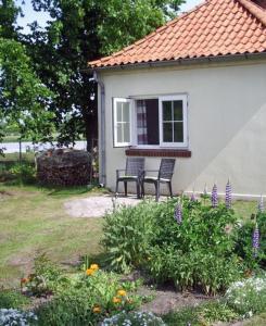 een huis met een bank in een tuin met bloemen bij Ferienhaus Strobel in Bardowick