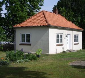 uma pequena casa branca com um telhado laranja em Ferienhaus Strobel em Bardowick