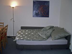 Bett in einem Zimmer mit einem Tisch und einer Lampe in der Unterkunft Ferienhaus Strobel in Bardowick