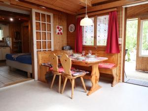 ein hölzernes Esszimmer mit einem Tisch und Stühlen in der Unterkunft Chalet Hügli by Interhome in Bure