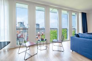 sala de estar con sofá azul y sillas en Homie Suites - Luxury Apartments in Maçka, en Estambul
