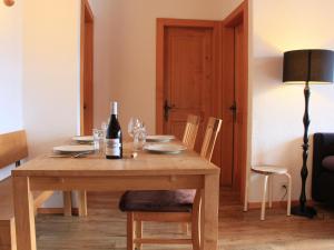 a wooden table with a bottle of wine on it at Apartment Le Geteillon 4 by Interhome in Chesières