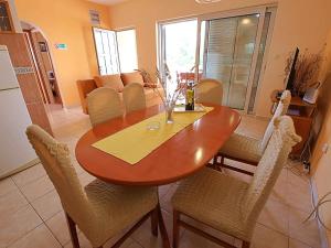 drewniany stół jadalny z krzesłami i kuchnia w obiekcie Holiday Home Anderson by Interhome w mieście Prigradica