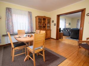 ein Wohnzimmer mit einem Holztisch und Stühlen in der Unterkunft Holiday Home Kleen by Interhome in Norden