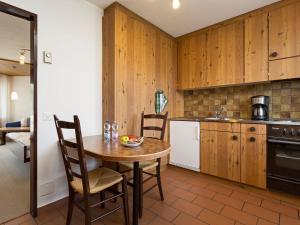 a kitchen with wooden cabinets and a table and chairs at Apartment Resort al Centro-1 by Interhome in Massagno