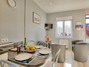 a dining room and living room with a table and chairs at Holiday Home La Corvette by Interhome in Pléneuf-Val-André +16 photos