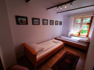 1 Schlafzimmer mit 2 Betten und einem Fenster in der Unterkunft Ułańska Zagroda in Człopa