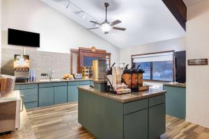 a large kitchen with blue cabinets and a ceiling at AmericInn by Wyndham Duluth South Proctor Black Woods Event Ctr in Duluth