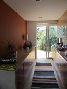 a kitchen with wooden cabinets and a sliding glass door at Casa da Ribeira in Aldeia do Meco
