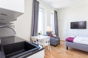 een kleine keuken en een woonkamer met een bank en een tafel bij ApartDirect Linköping Vasastaden in Linköping