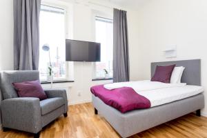 una camera con letto e sedia di ApartDirect Linköping Vasastaden a Linköping