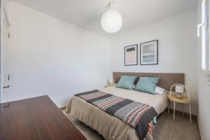 ein weißes Schlafzimmer mit einem Bett und einem Tisch in der Unterkunft Sweet La Ola in La Santa