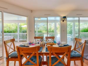 een eetkamer met een tafel, stoelen en ramen bij Holiday Home Eden Parc by Interhome in Lacanau-Océan