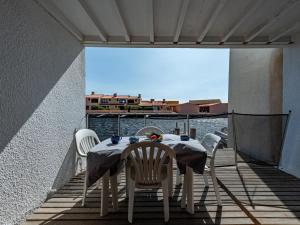 a table and chairs on a balcony with a view of the water at Holiday Home Les Brigantins-3 by Interhome in Port Leucate
