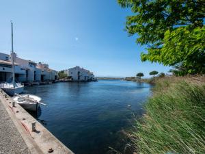 a boat is docked in a river next to buildings at Holiday Home Les Brigantins-3 by Interhome in Port Leucate