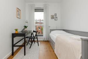 1 dormitorio con cama, escritorio y ventana en Modern Apartment Stalowa 2 bedrooms & Parking by Renters, en Varsovia