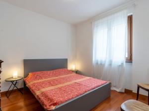 ein Schlafzimmer mit einem Bett mit einer roten Bettdecke und einem Fenster in der Unterkunft Villa Col di Rodi by Interhome in Sanremo