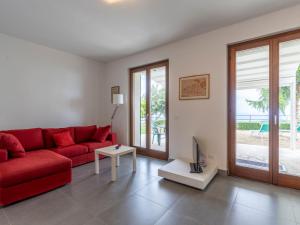 ein Wohnzimmer mit einem roten Sofa und einem TV in der Unterkunft Villa Col di Rodi by Interhome in Sanremo