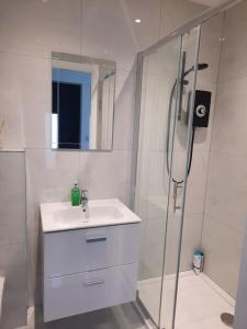 een witte badkamer met een wastafel en een douche bij Guest house in Dublin in Cluain Aodha