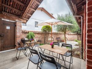 un patio con mesa de madera, sillas y sombrilla en Holiday Home La Grotta di Cech by Interhome en Narzole