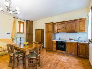 a kitchen with wooden cabinets and a wooden table at Apartment Rosa by Interhome in Badia Agnano +51 photos